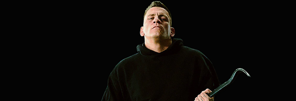 Es ist das Albumcover von Gzuz zu sehen, der vor einem schwarzen Hintergrund steht und mit ernstem Blick in die Kamera schaut. 